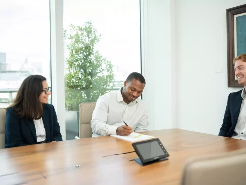 London trainee solicitors in a law firm meeting room during discussion.