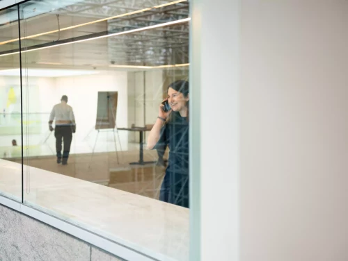 Solicitor speaking on the phone inside a modern office building.
