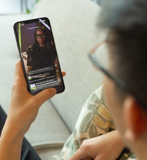 Aspiring solicitor watching the HL Legal Lounge Podcast on a smartphone.